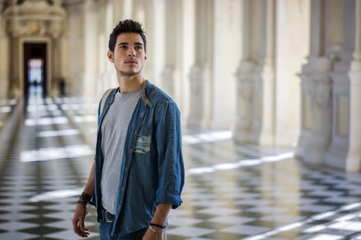 Half Body Shot of a Thoughtful Handsome Young Man, Looking Away Inside a Museum