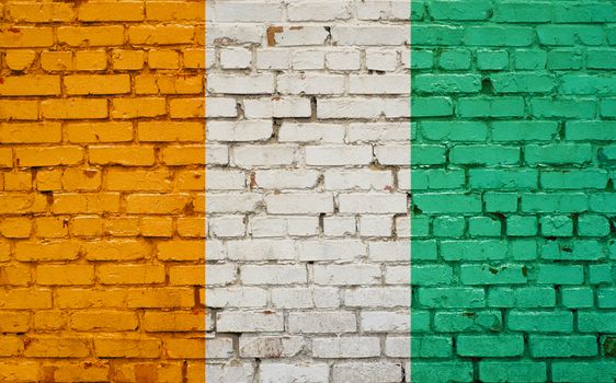 Flag of Cote d'ivoire painted on brick wall, background texture