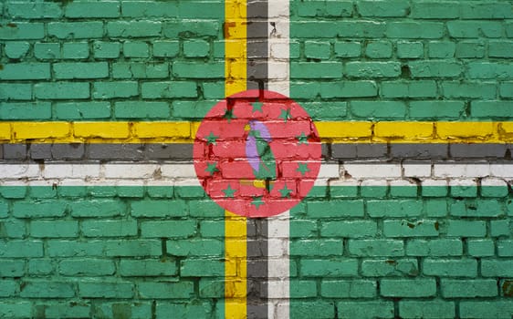 Flag of Dominca painted on brick wall, background texture