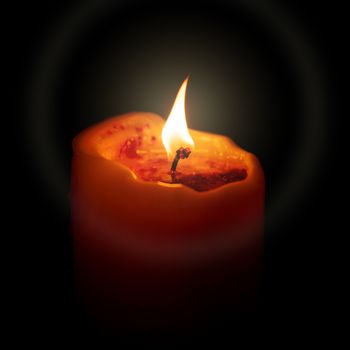 An image of a red candle in the dark