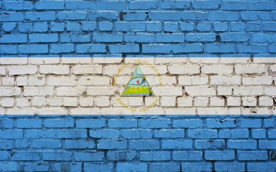 Flag of Nicaragua painted on brick wall, background texture