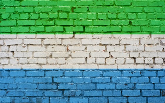 Flag of Sierra Leone painted on brick wall, background texture