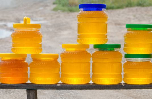 Different varieties of honey in plastic banks for sale beside the road