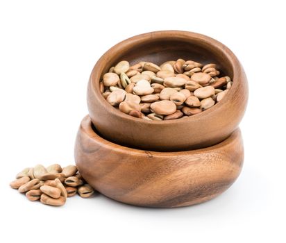 dried fava (broad) bean in a rustic wood bowl isolated on white