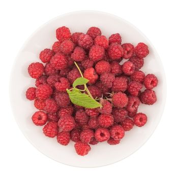 Plate with fresh raspberries on white background