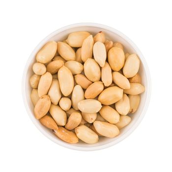 At the center of the frame white bowl roasted peanuts on a white background.  Top view.