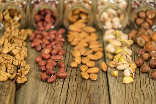 Mix of nuts in the glass jars , on the table, selective focus