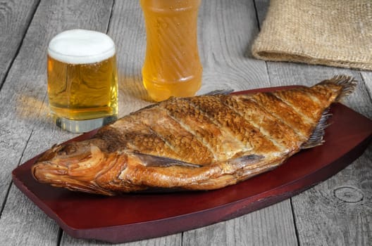 Smoked fish and beer, on the surface of the old gray boards