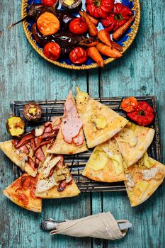 Pizza stuffed with meat and baked vegetables in rustic style