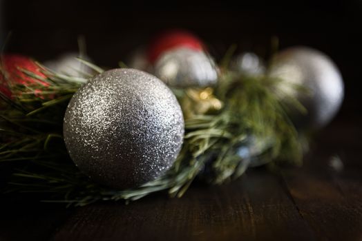 Christmas wreath of fir branches with Christmas decorations, pine cones and gifts on the brown background