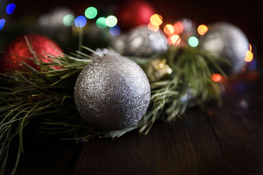 Christmas wreath of fir branches with Christmas decorations, pine cones and gifts on the brown background