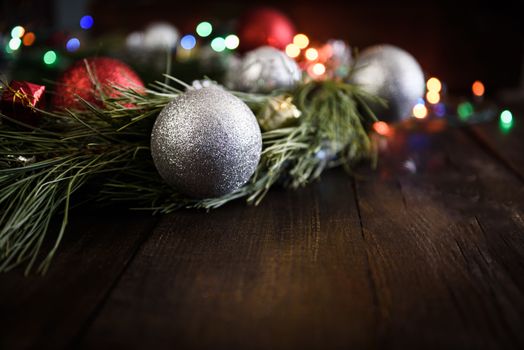 Christmas wreath of fir branches with Christmas decorations, pine cones and gifts on the brown background