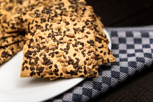 cookies with sunflower seeds and sesame seeds on a white plate with checkered napkin