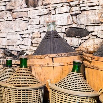 Demijohns of wine in a stone cellar.