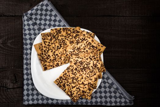 cookies with sunflower seeds and sesame seeds on a white plate with checkered napkin