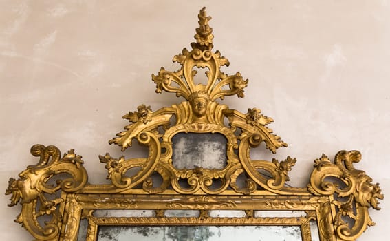 Detail of gilded wooden frame of an antique mirror.