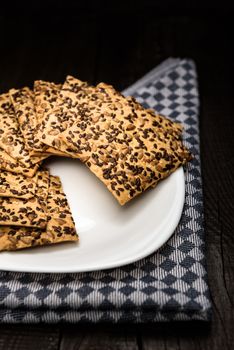 cookies with sunflower seeds and sesame seeds on a white plate with checkered napkin