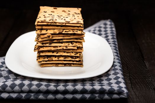 cookies with sunflower seeds and sesame seeds on a white plate with checkered napkin