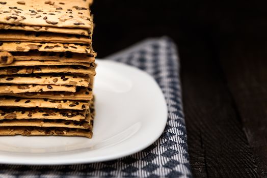 cookies with sunflower seeds and sesame seeds on a white plate with checkered napkin