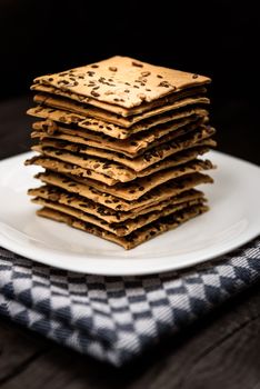 cookies with sunflower seeds and sesame seeds on a white plate with checkered napkin