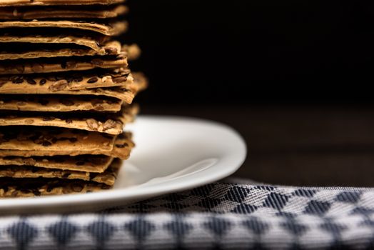 cookies with sunflower seeds and sesame seeds on a white plate with checkered napkin