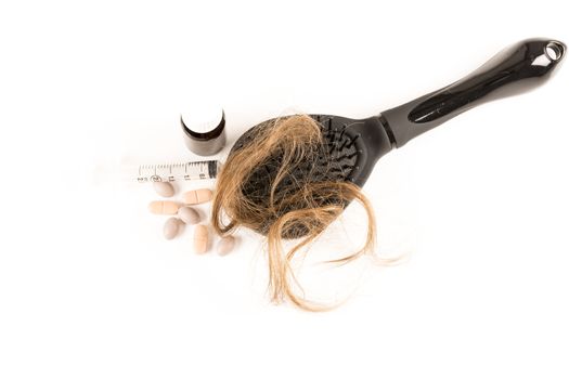 Close-up of hair loss, long hair, alopecia treatment on white background with brush