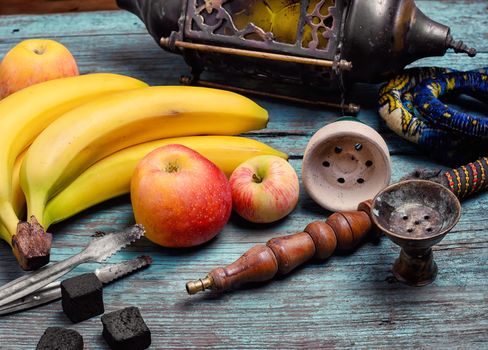 Part of the hookah,stylish arabic lamp and bananas with apple