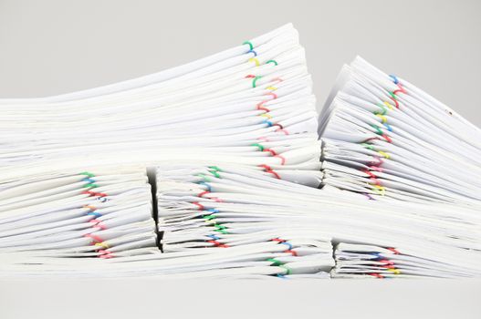 Pile overload report and receipt with colorful paperclip place on white background.