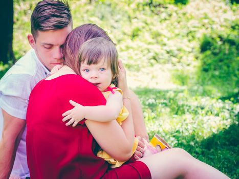 Mother holding her crying one-year old baby girl. Sad expression - family concept