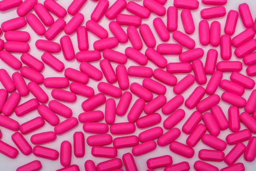 Pills, pink capsules, vitamins on white background