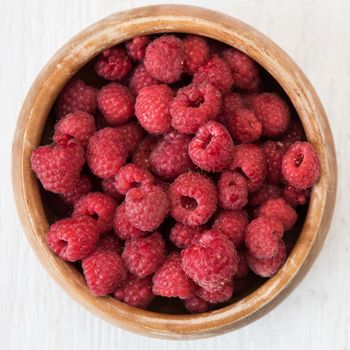 Fresh ripe raspberry on a wooden plate