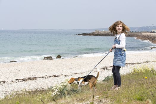 A child girl on a walk with a little dog