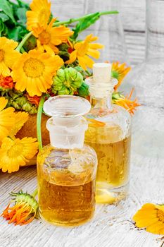 Blooming calendula and jars of prepared medicinal extract