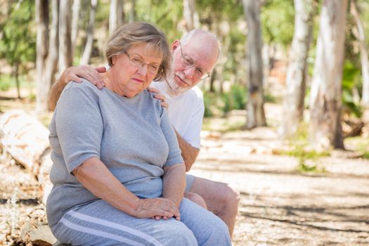 Very Upset Senior Woman Sits With Concerned Husband Outdoors.