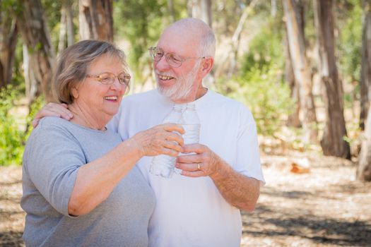Happy Healthy Senior Couple with Water Bottles Outdoors.