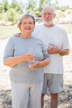 Happy Healthy Senior Couple with Water Bottles Outdoors.