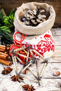 Pine and pinecone Christmas decorations on snowy wooden background