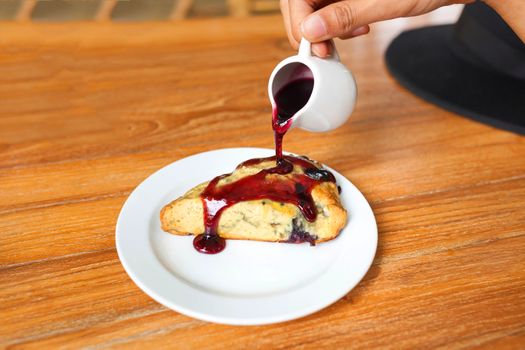 Tasty pie with raspberry jam on wood table.