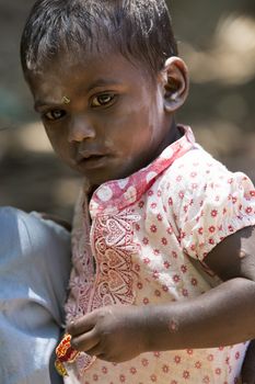 Documentary editorial image. Pondicherry, Tamil Nadu, India - June 15 2014. Very poor young boy in his sister arms. Poverty