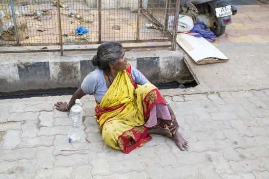 Documentary editorial image. Pondicherry, Tamil Nadu, India - June 23 2014. Very poor woman sitting in the street asking for food Poverty
