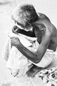 Documentary editorial image. Pondicherry, Tamil Nadu, India - June 24 2014. homeless and poor people writing, sleeping, walking in the street