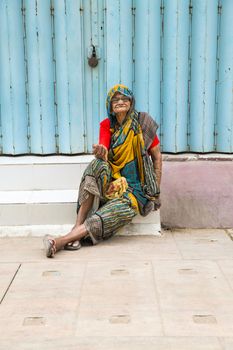 Documentary editorial image. Pondicherry, Tamil Nadu, India - June 23 2014. Very poor woman sitting in the street asking for food Poverty