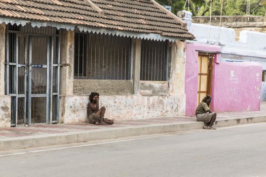 Documentary editorial image. Pondicherry, Tamil Nadu, India - June 24 2014. homeless and poor people writing, sleeping, walking in the street