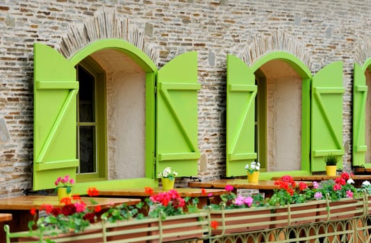 Wooden green house windows and beautiful street decorated with flowers 