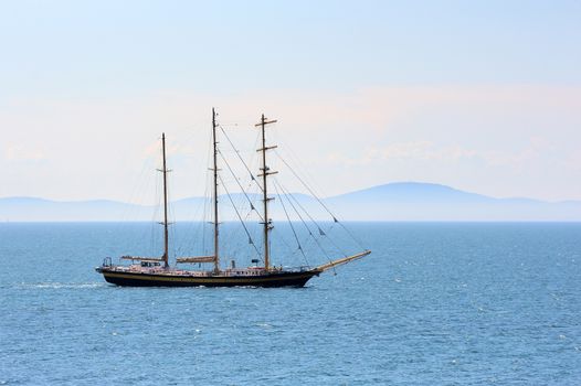 Ship sailing in the sea on mountain background