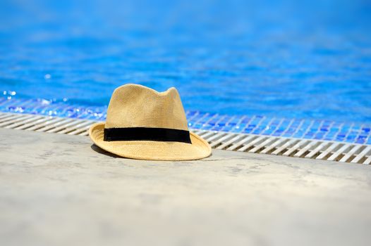 Sun hat on the edge of the pool in hotel