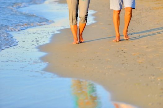 close-up of a romantic couple walking together along the beach