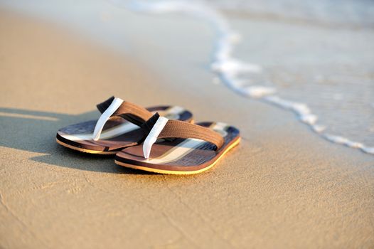 Summer vacation concept. Flip flops on a sandy ocean beach