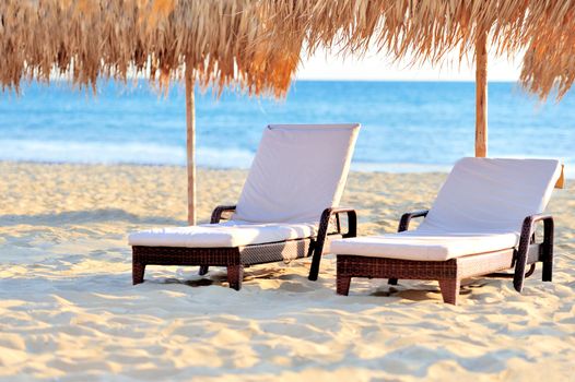 Two beach chairs with white umbrella