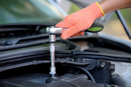 Hands of car mechanic in auto repair service